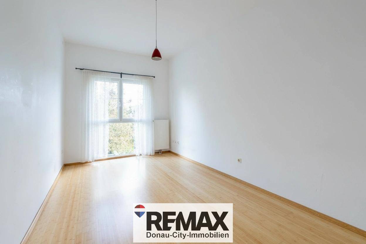 Geräumiges Zimmer mit hellem Holzfußboden und großem Fenster für viel Tageslicht.