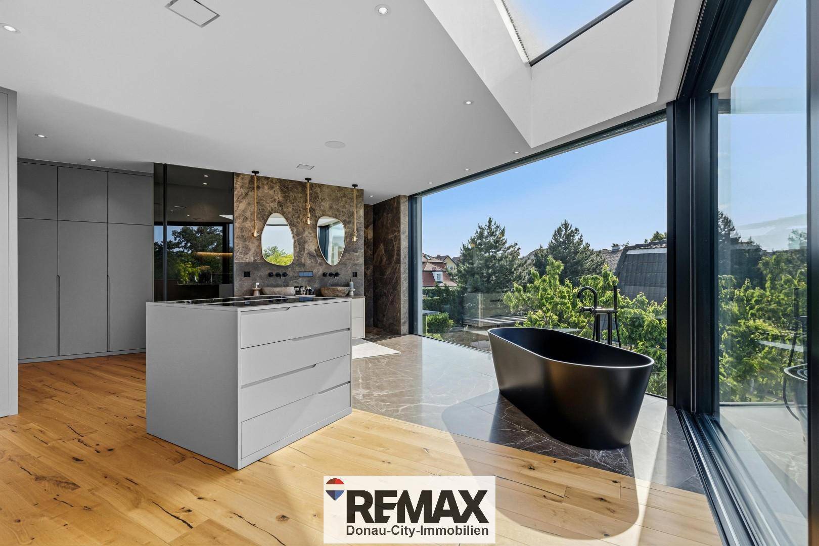 Exklusives Schlafzimmer mit Doppelwaschbecken, freistehender Badewanne und Panoramablick.