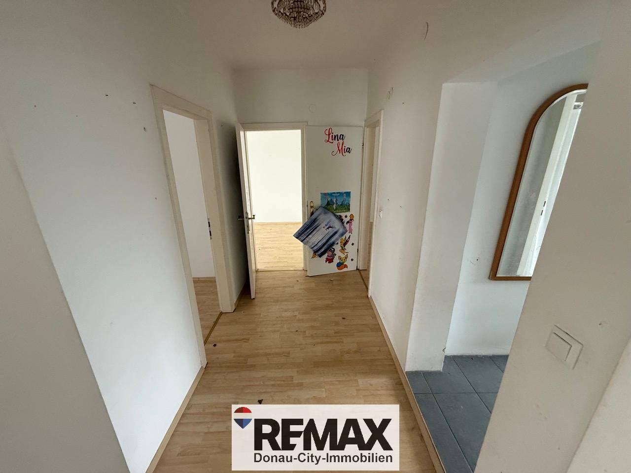 Langer Flur mit Laminatboden und mehreren Türen, der zu verschiedenen Räumen im Haus führt.