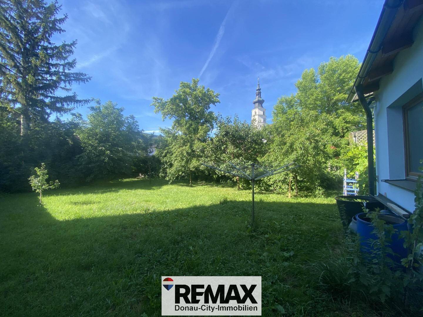 Großer grüner Garten mit Rasenfläche und Bäumen, ideal für Erholung im Freien.