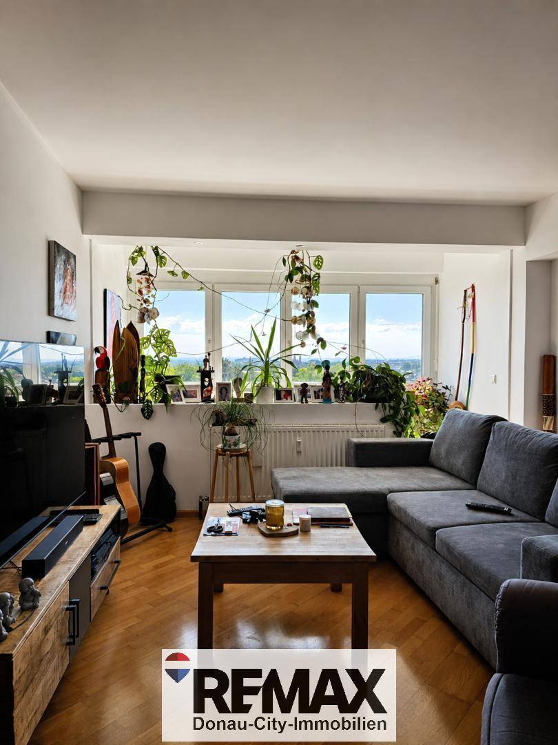 Gemütliches Wohnzimmer mit großem Ecksofa, Couchtisch und Fenstern mit weitem Ausblick.