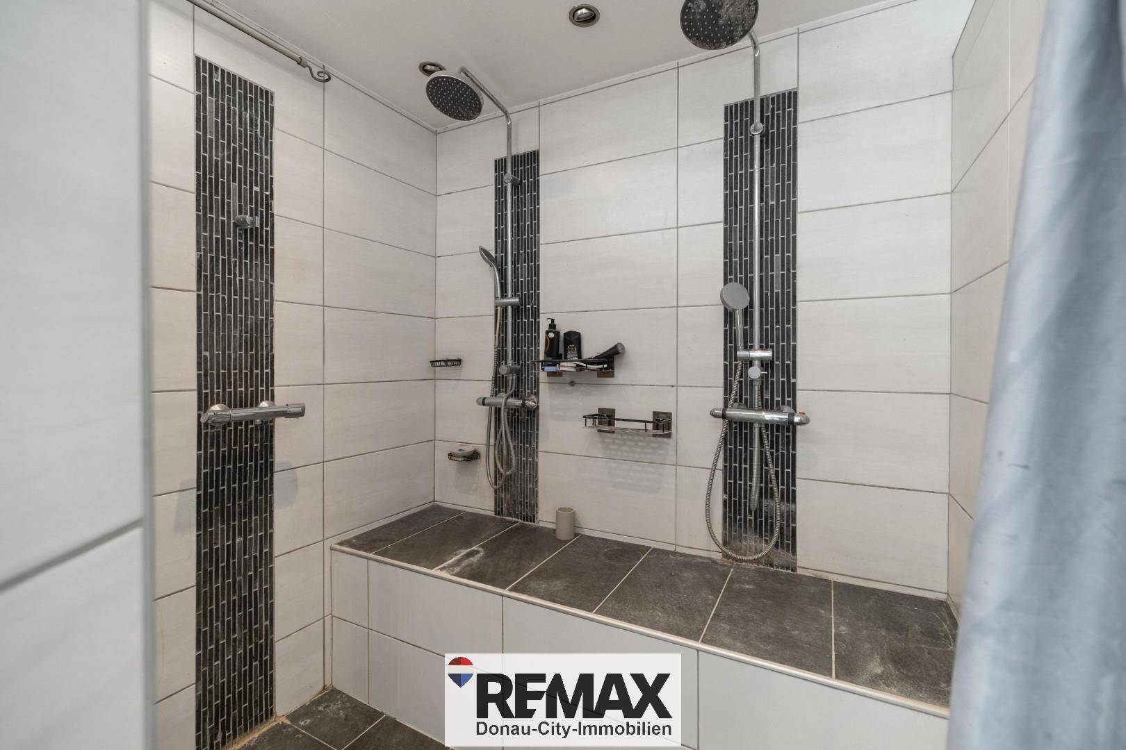 Modernes Badezimmer mit zwei geräumigen begehbaren Duschen und eleganten Fliesen.