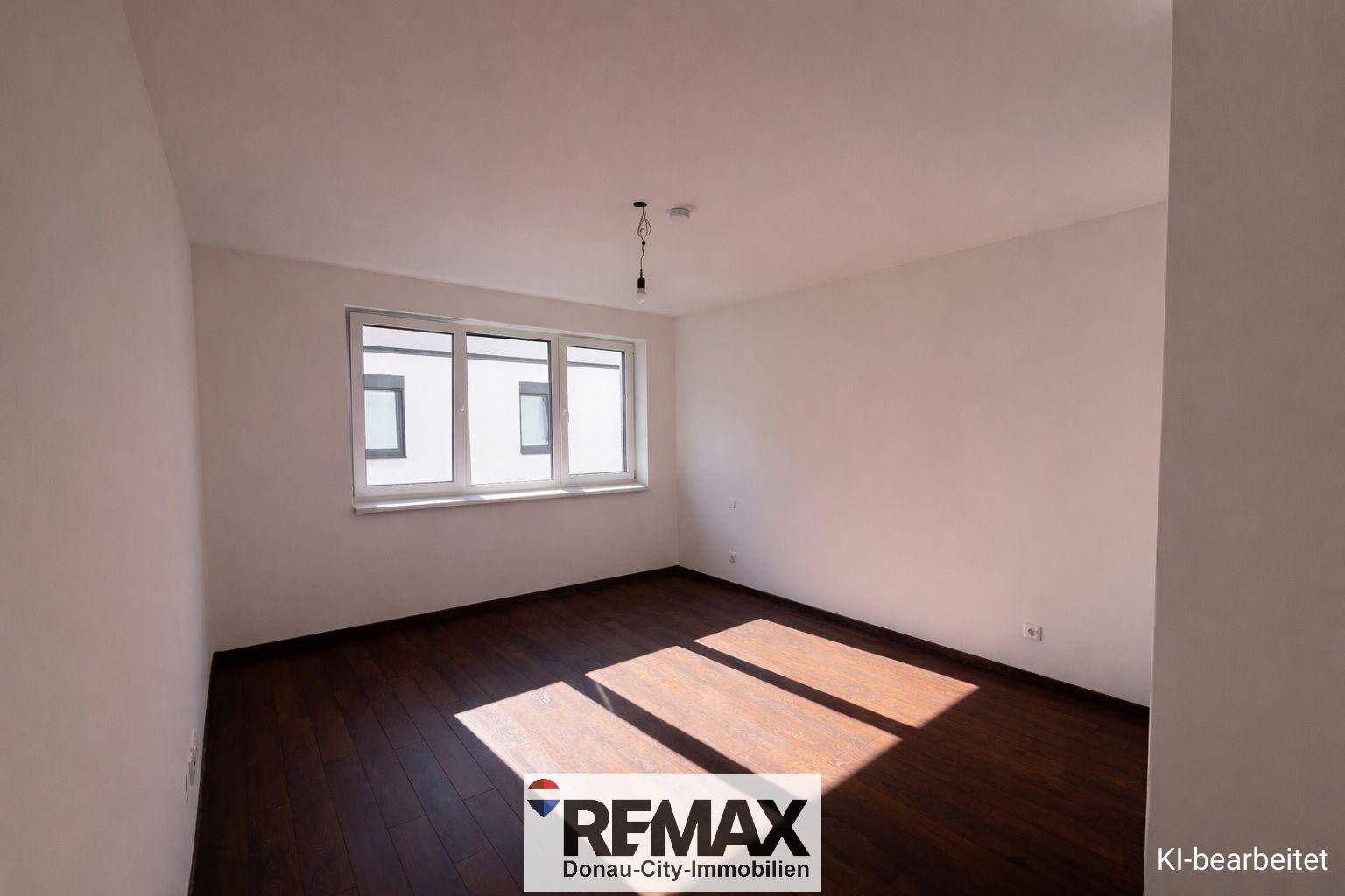 Helles Schlafzimmer mit dunklem Boden und einem großen Fenster, bereit zur individuellen Gestaltung.