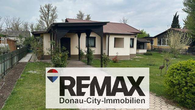 Hausansicht mit überdachtem Eingangsbereich und gepflegtem Rasen.