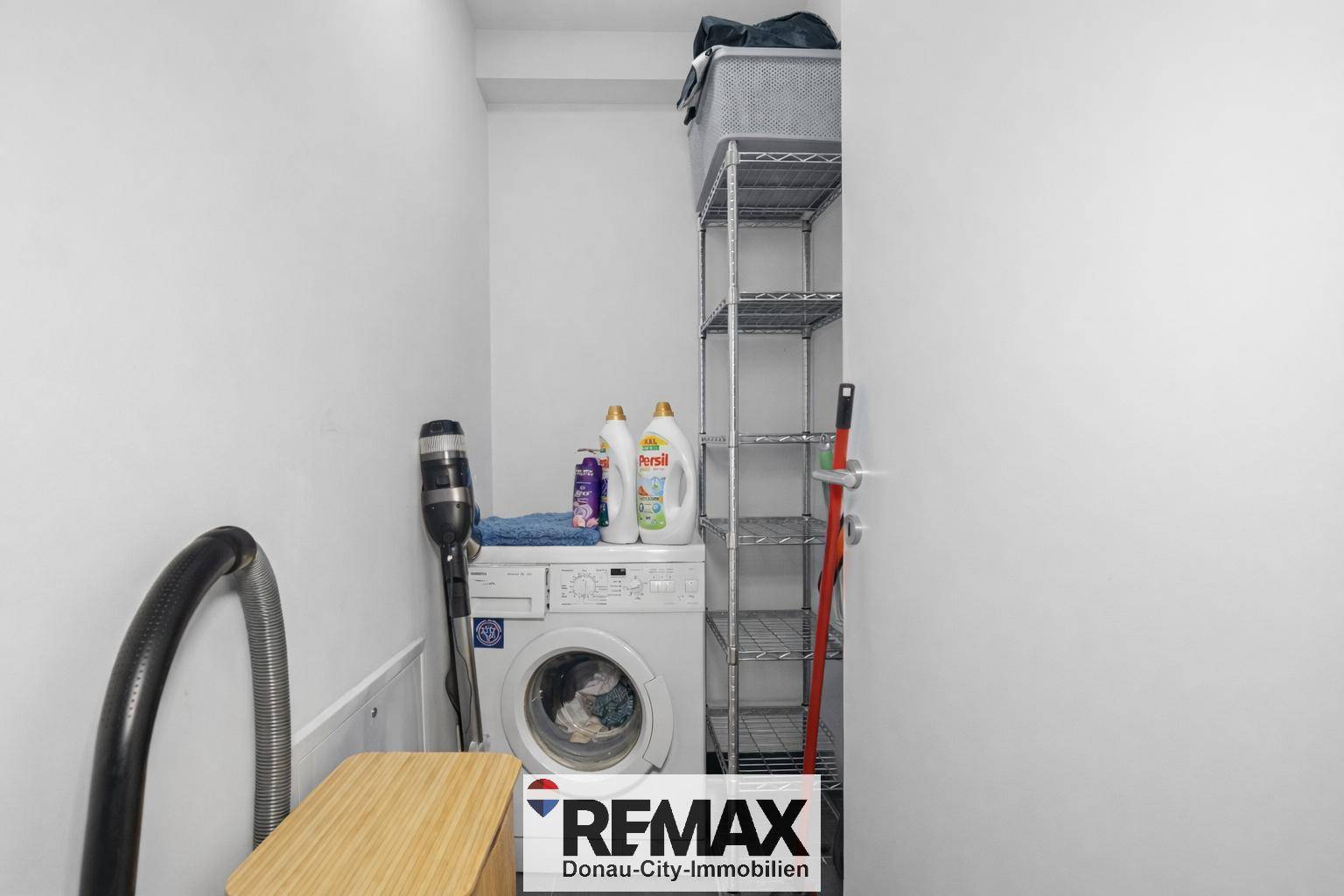 Praktischer Hauswirtschaftsraum mit Waschmaschine und Regalsystem.