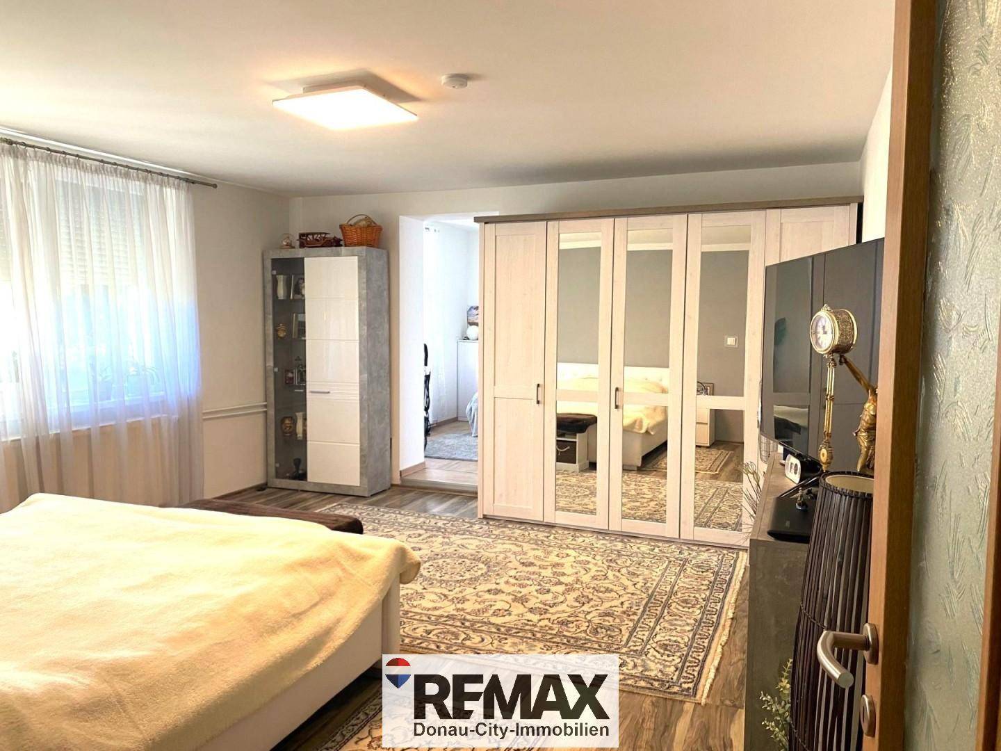 Geräumiges Schlafzimmer mit großem Kleiderschrank und Teppichboden, bietet viel Stauraum.