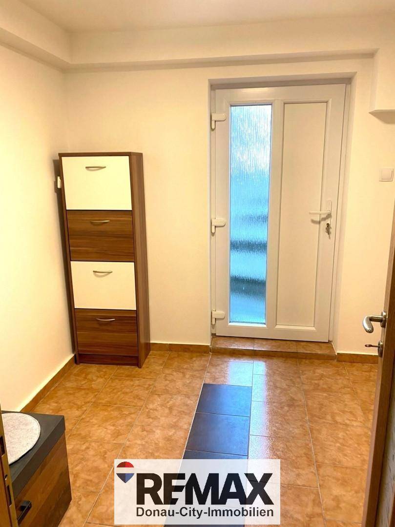Eingangsbereich mit Fliesenboden und Schuhschrank, bietet praktischen Stauraum.