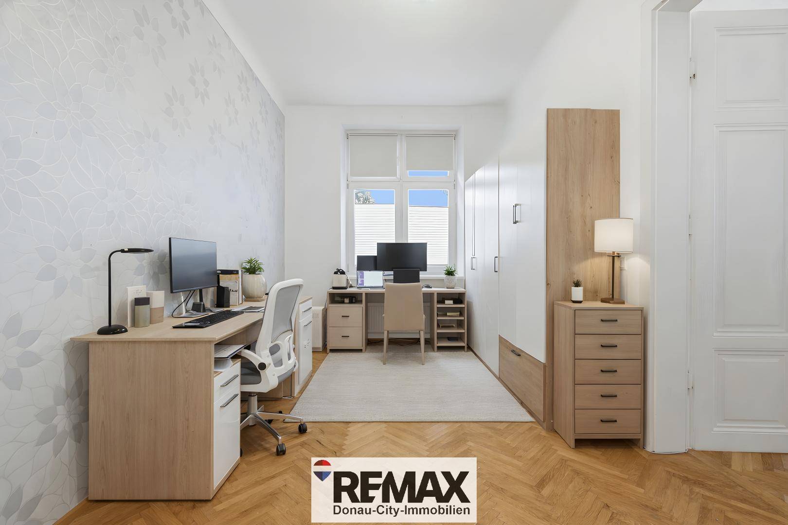 Helles Arbeitszimmer mit zwei Schreibtischen, Stauraum und Fischgrätparkett.
