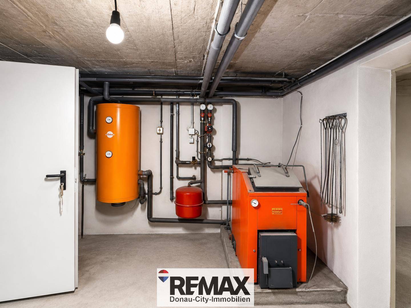 Heizraum im Keller mit älterer, aber funktionaler Heizungsanlage und Warmwasserspeicher.