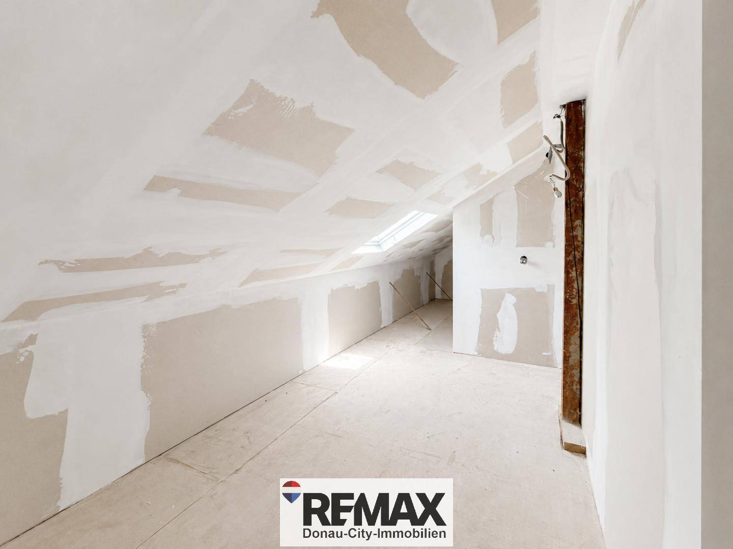 Dachgeschossbereich in Renovierung mit Dachschräge und Dachfenster, bereit zum Ausbau.