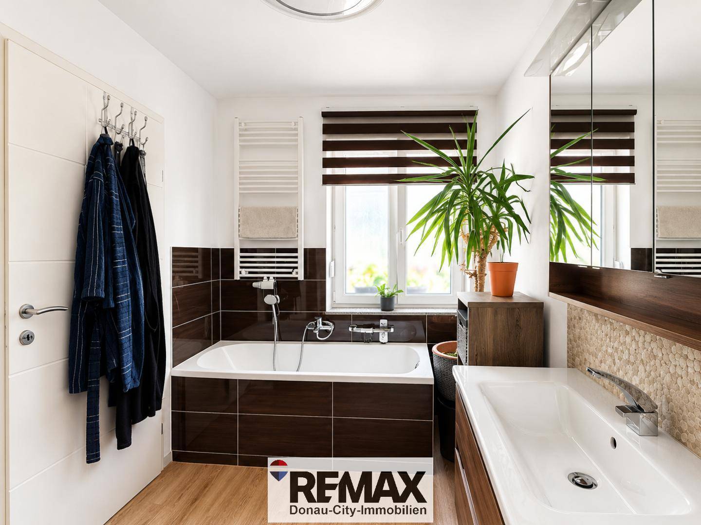 Modernes Badezimmer mit Badewanne, Waschtisch und beheiztem Handtuchhalter.