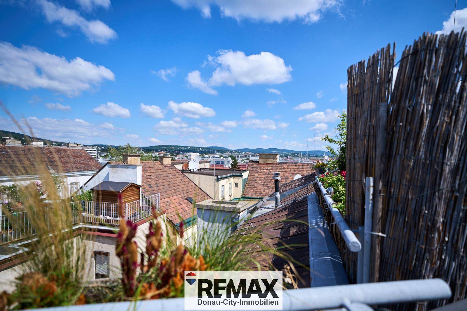 Panoramablick von einem Balkon über die Dächer der Stadt und die umliegende Landschaft.