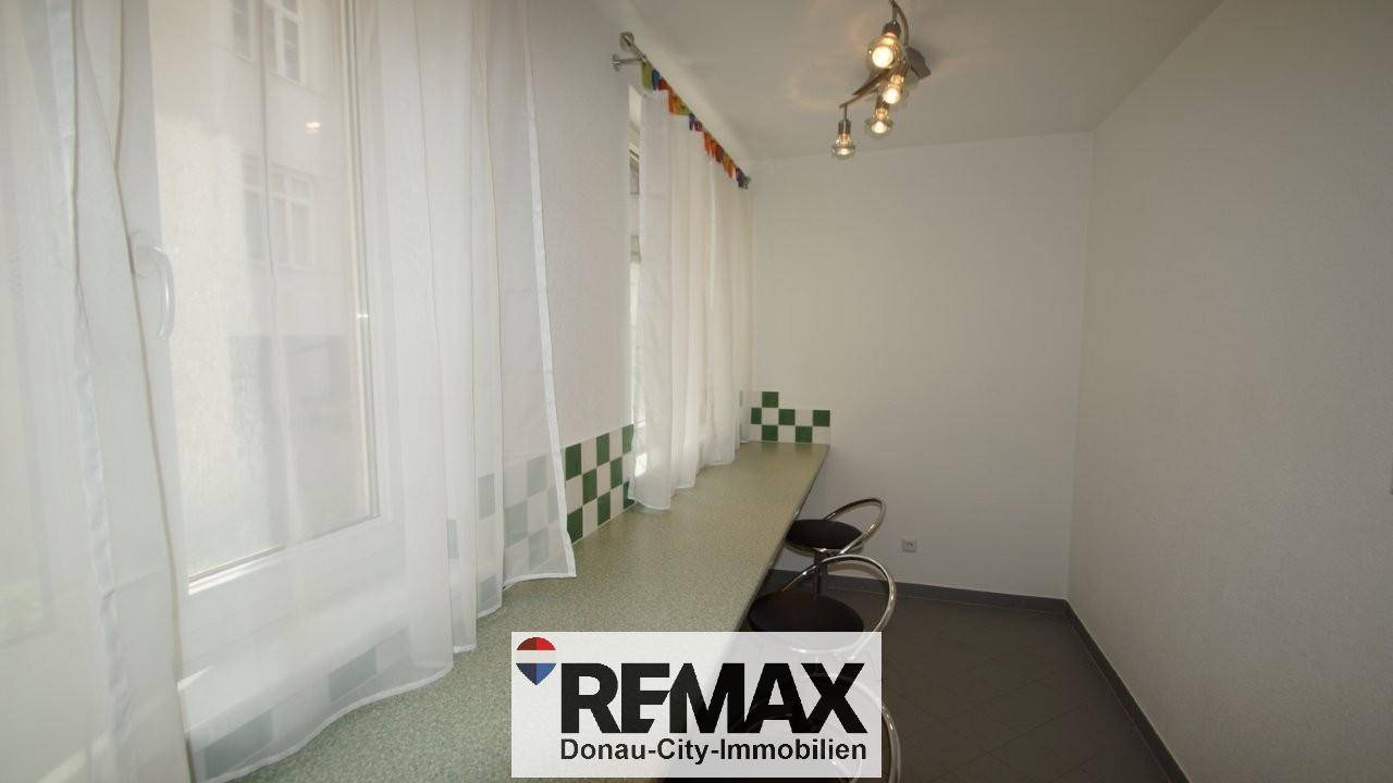 Heller Essbereich mit Frühstücksbar und Hockern am Fenster, ideal für schnelle Mahlzeiten.