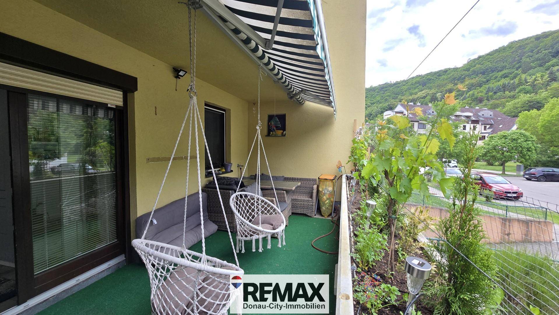 Gemütlicher Balkon mit Hängesesseln, Sitzgelegenheiten und einem schönen Blick auf die grüne Landschaft.
