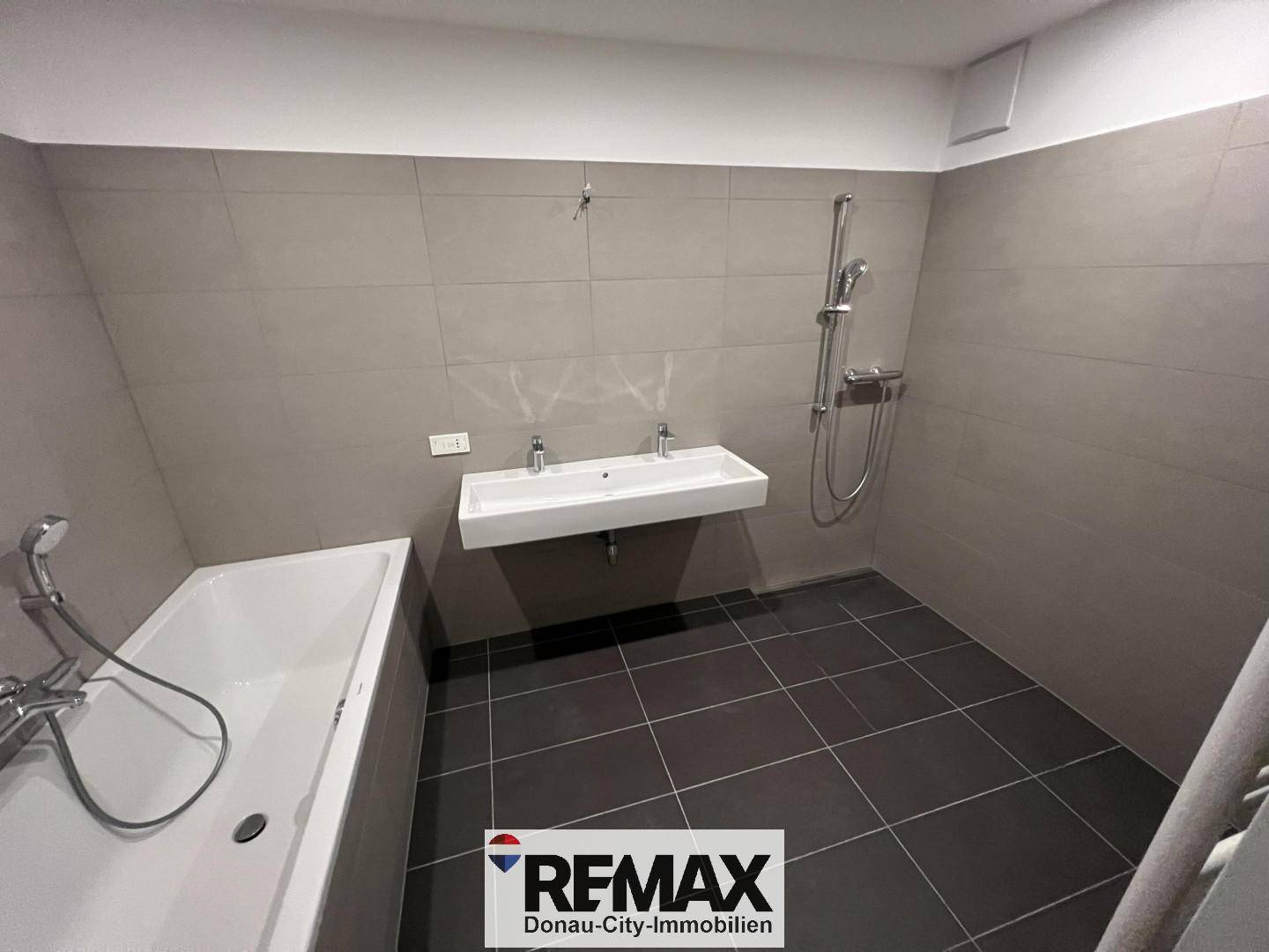 Geräumiges Badezimmer mit Badewanne, Dusche und Doppelwaschbecken, bereit zur Fertigstellung.