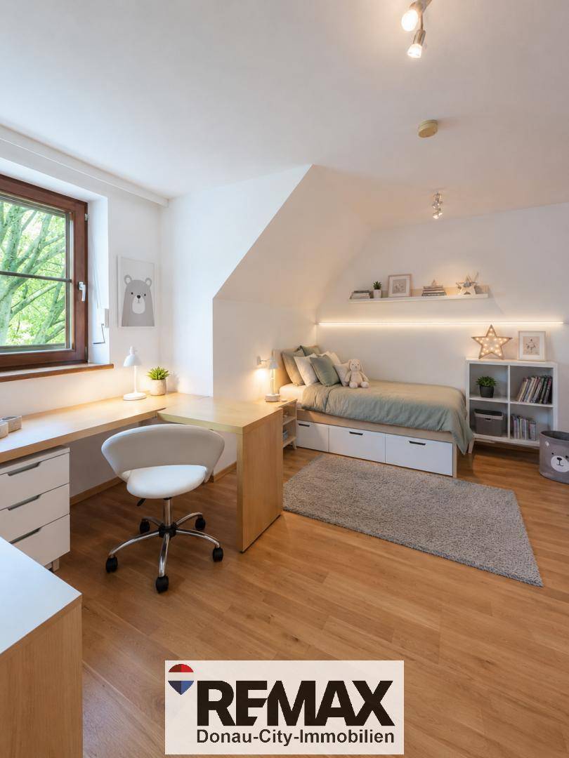 Helles Kinderzimmer mit Schreibtisch, Bett und Dachschräge mit Fenster.
