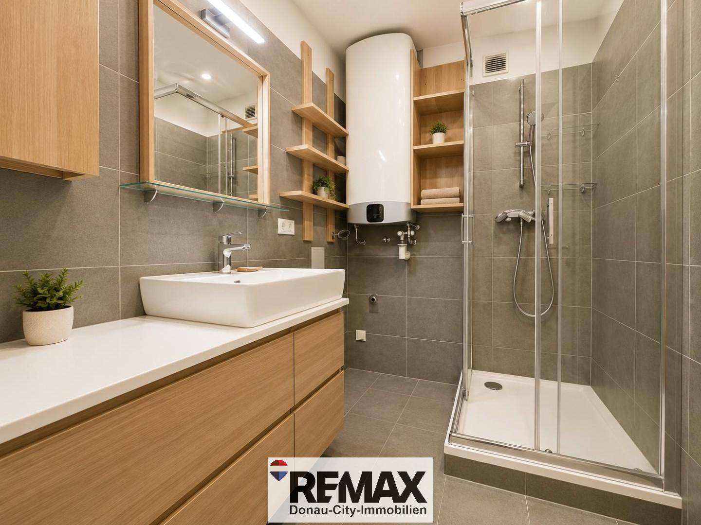 Modernes Badezimmer mit grauen Fliesen, Duschkabine, Einzelwaschbecken und Holzregalen.
