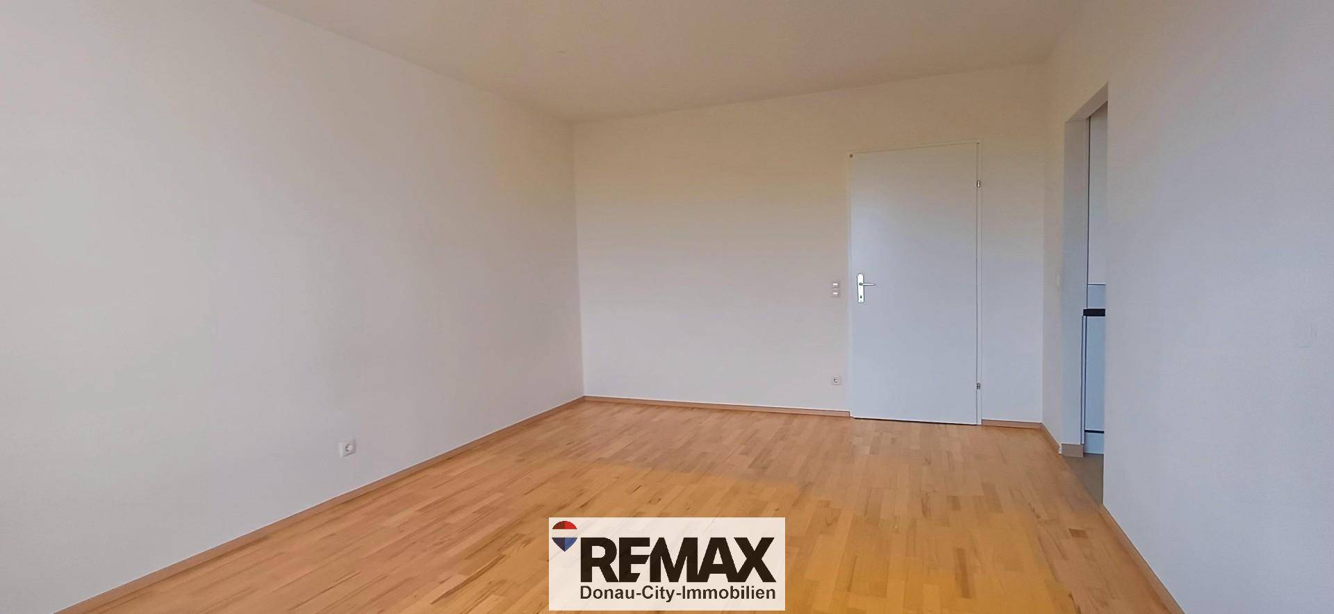 Leeres Zimmer mit hellem Holzboden und weiß gestrichenen Wänden, bereit zur individuellen Gestaltung.