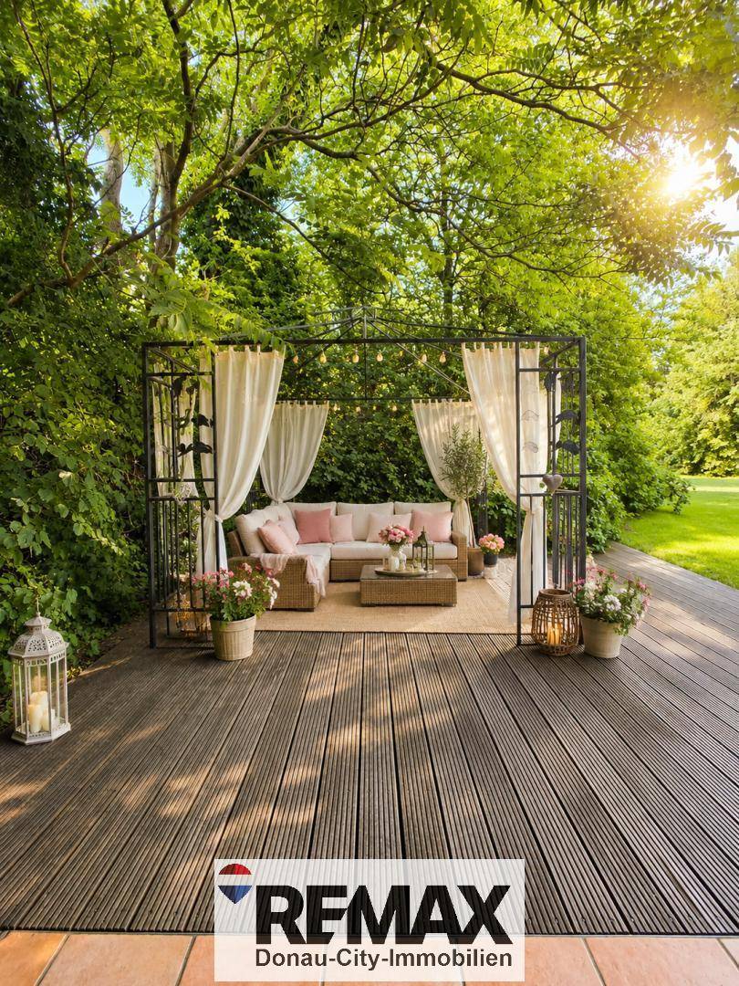 Idyllischer Gartenbereich mit Holzterrasse und einem Pavillon mit Lounge-Möbeln.