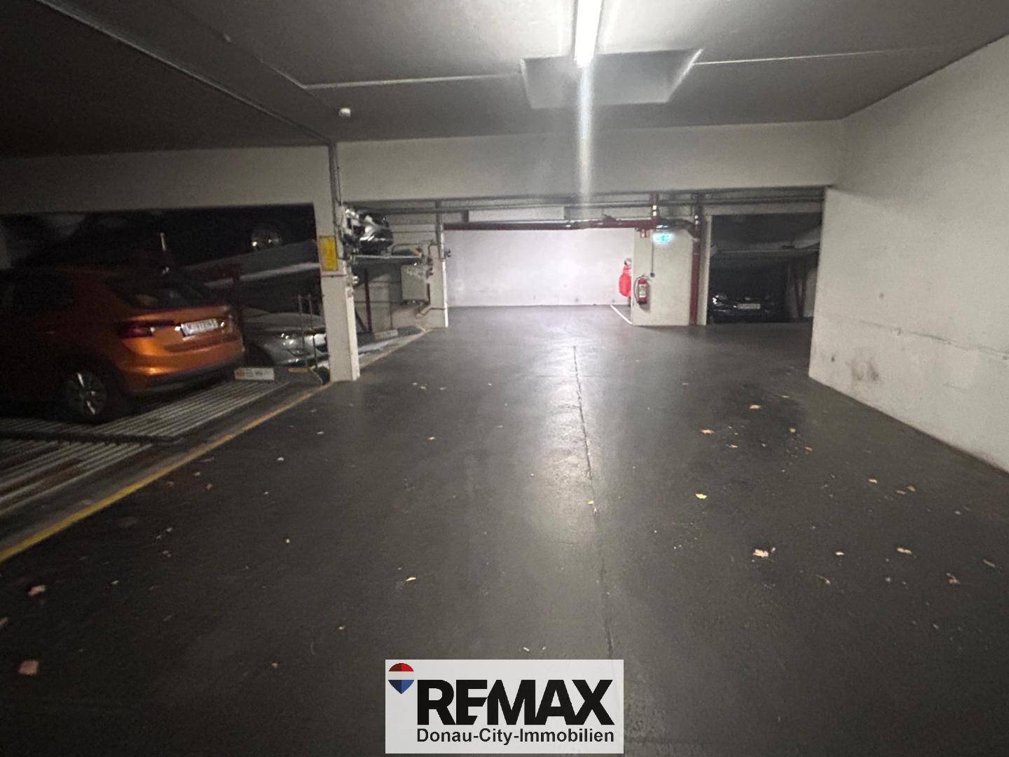 Geräumige Tiefgarage mit mehreren Parkplätzen und Auto-Liftsystemen für effizientes Parken.