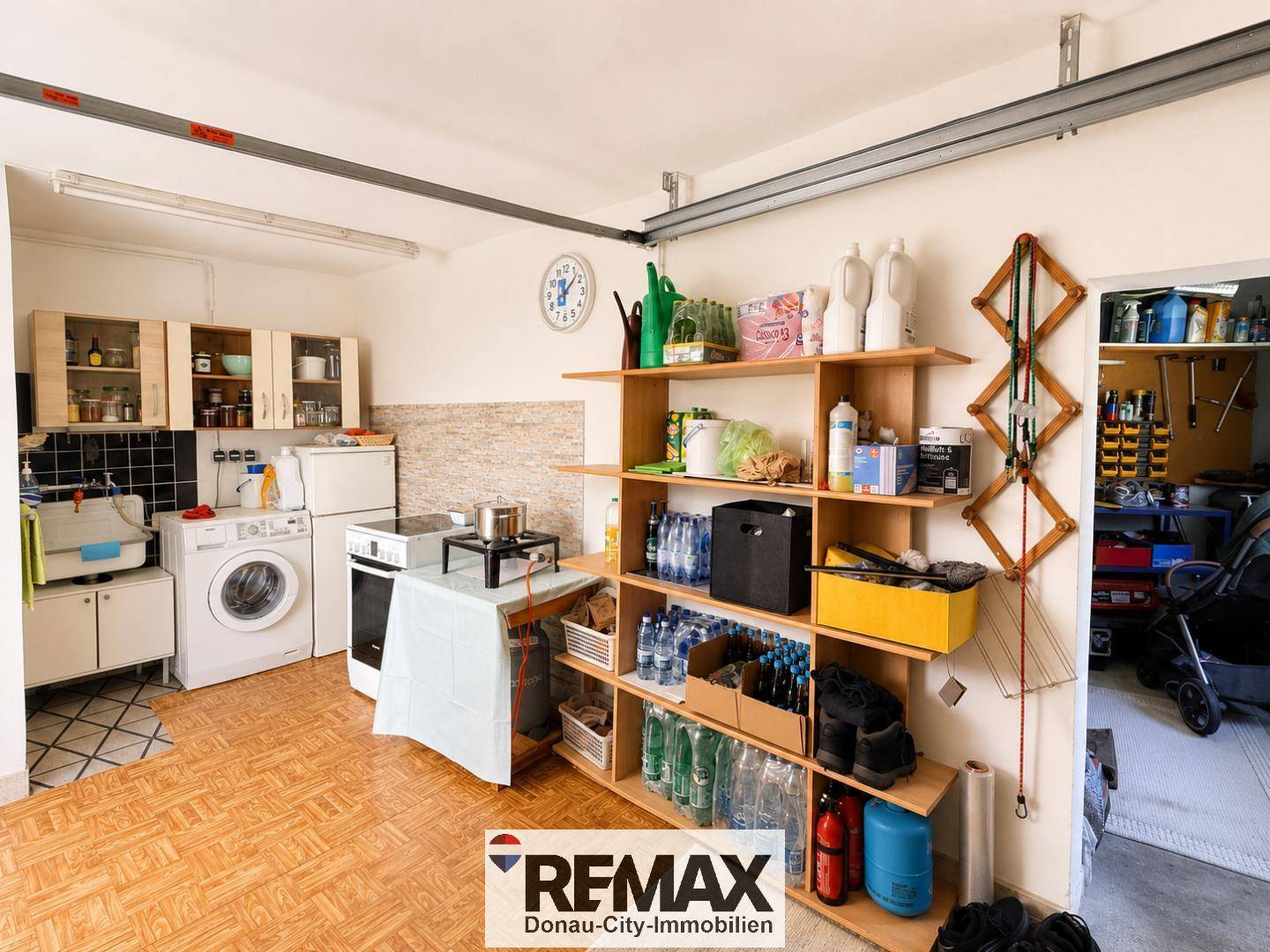 Geräumige Garage mit Regalen, Waschmaschine und viel Stauraum für Haushaltsgeräte.