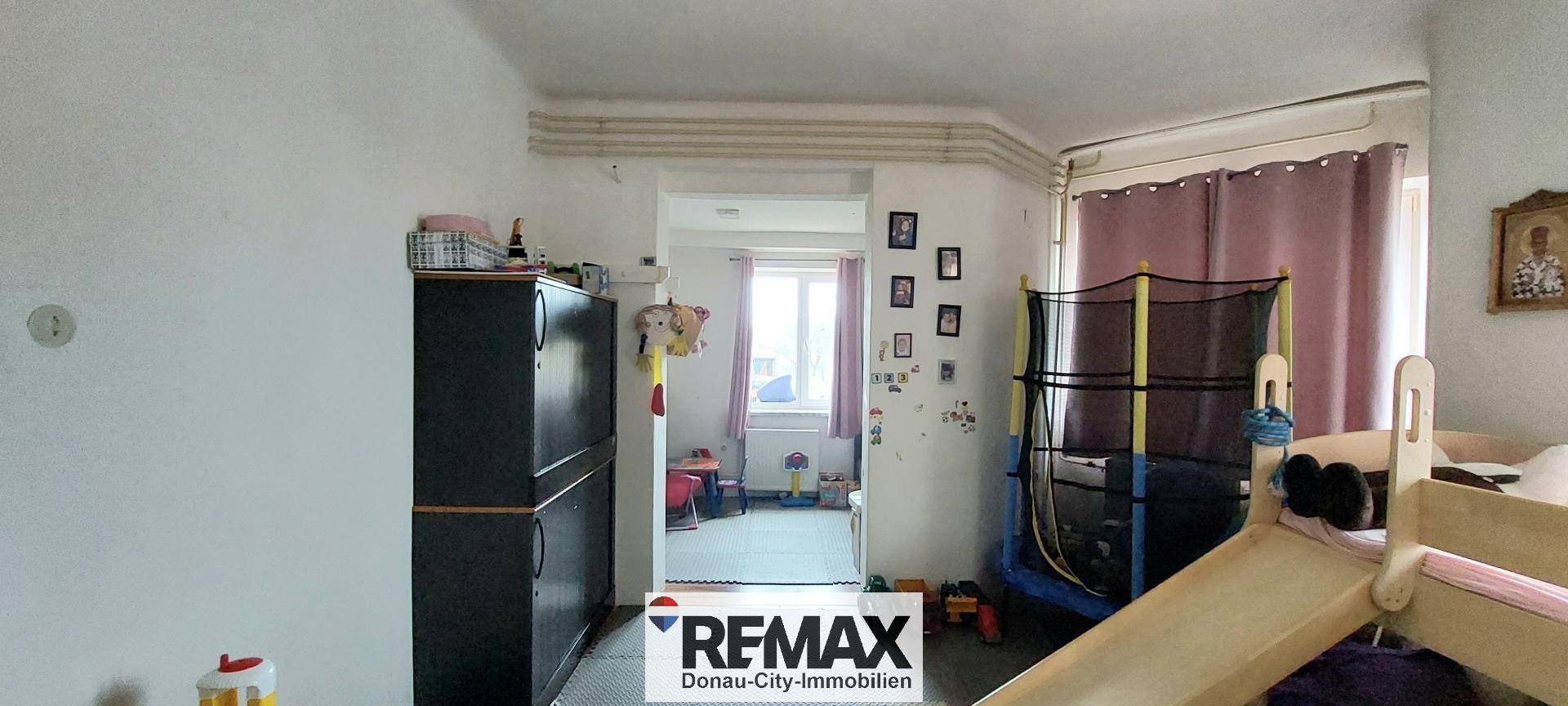 Flur oder Spielbereich mit Trampolin und Rutsche, bietet Platz für Aktivitäten.