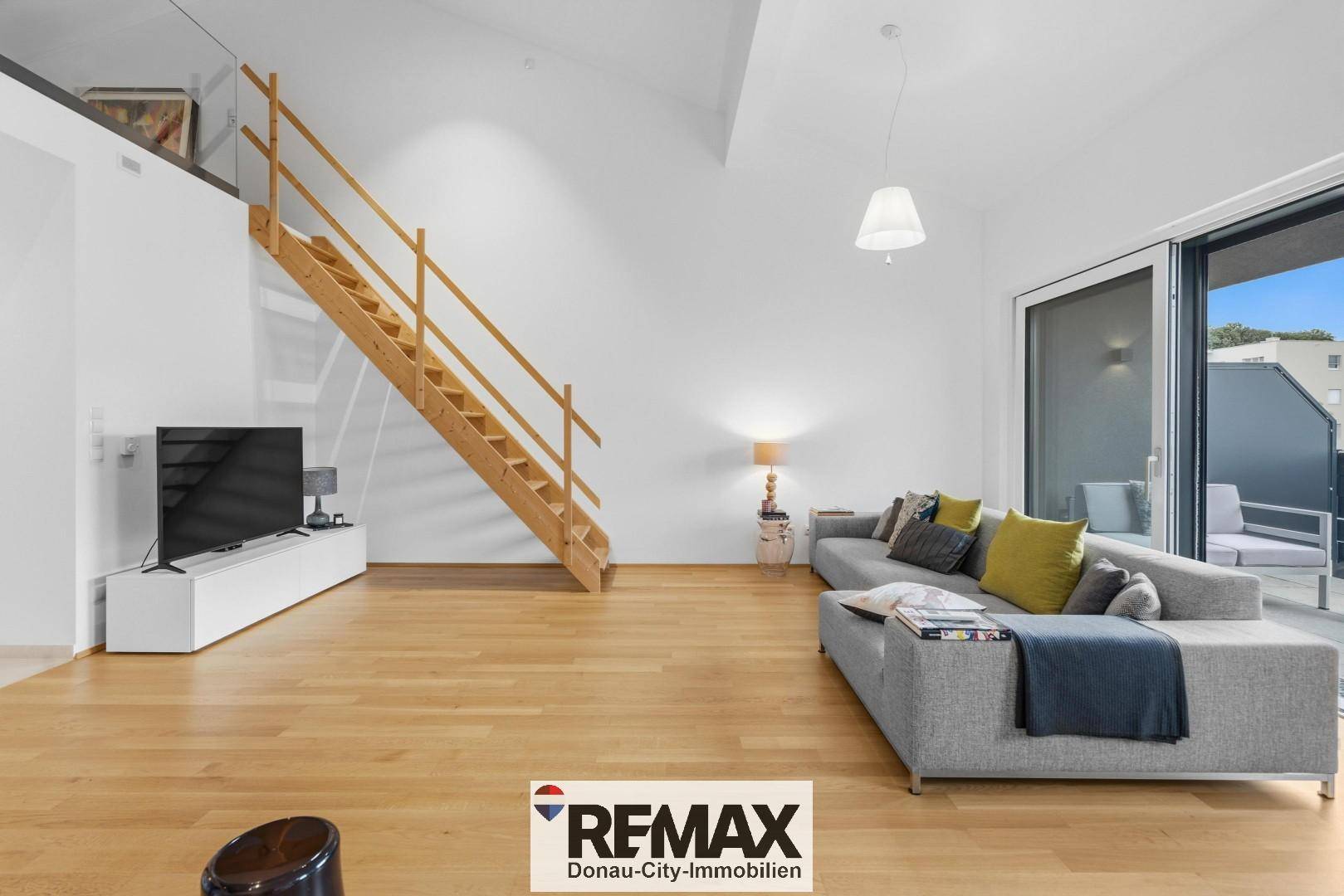 Helles Wohnzimmer mit bequemer Couch, TV-Möbel und direktem Zugang zur Terrasse.