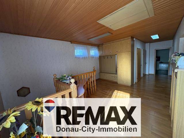 Obergeschoss-Flur mit Holzfußboden, Holzdecke und praktischen Einbauschränken.