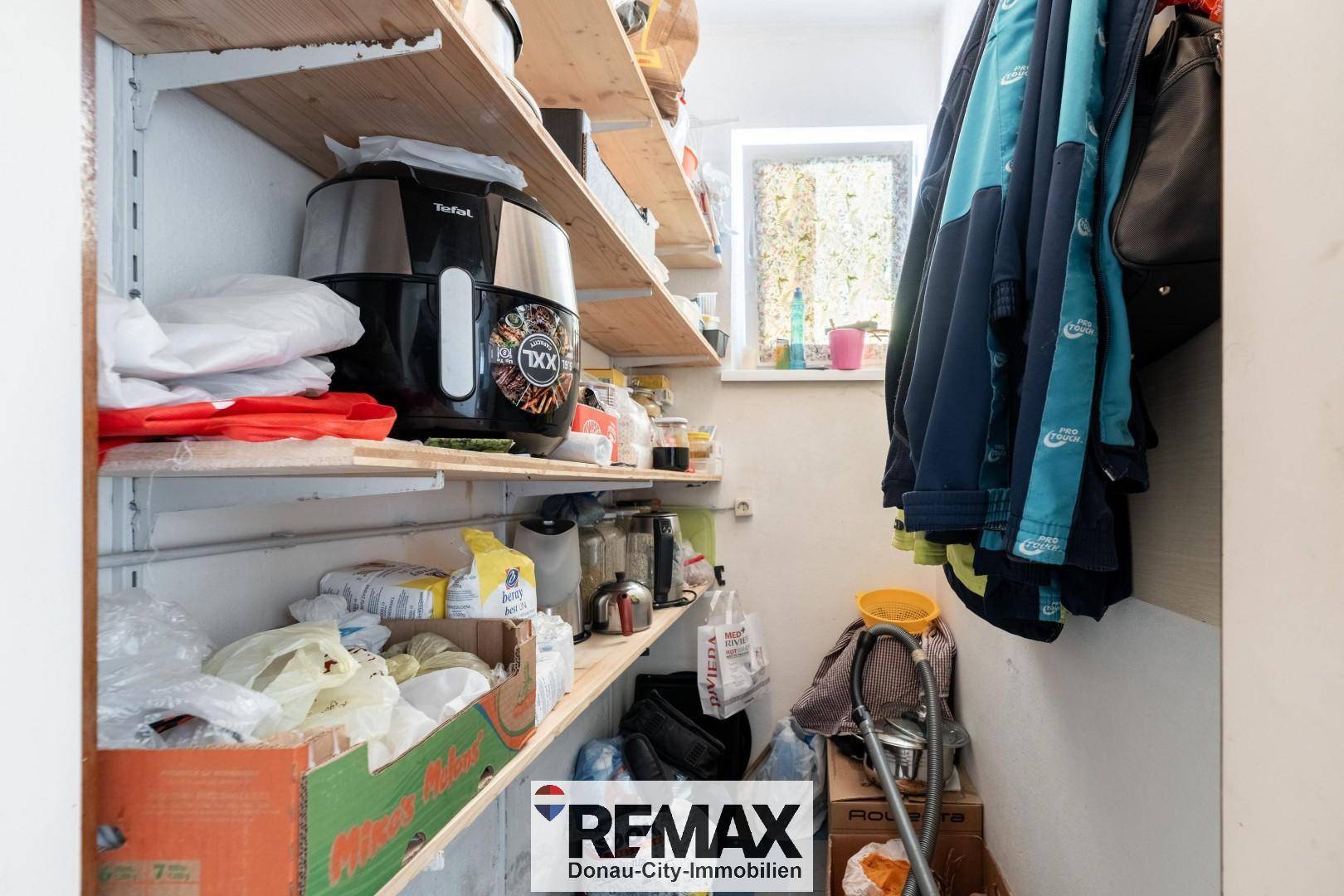 Praktische Speisekammer mit Regalen für Vorräte und einem kleinen Fenster.