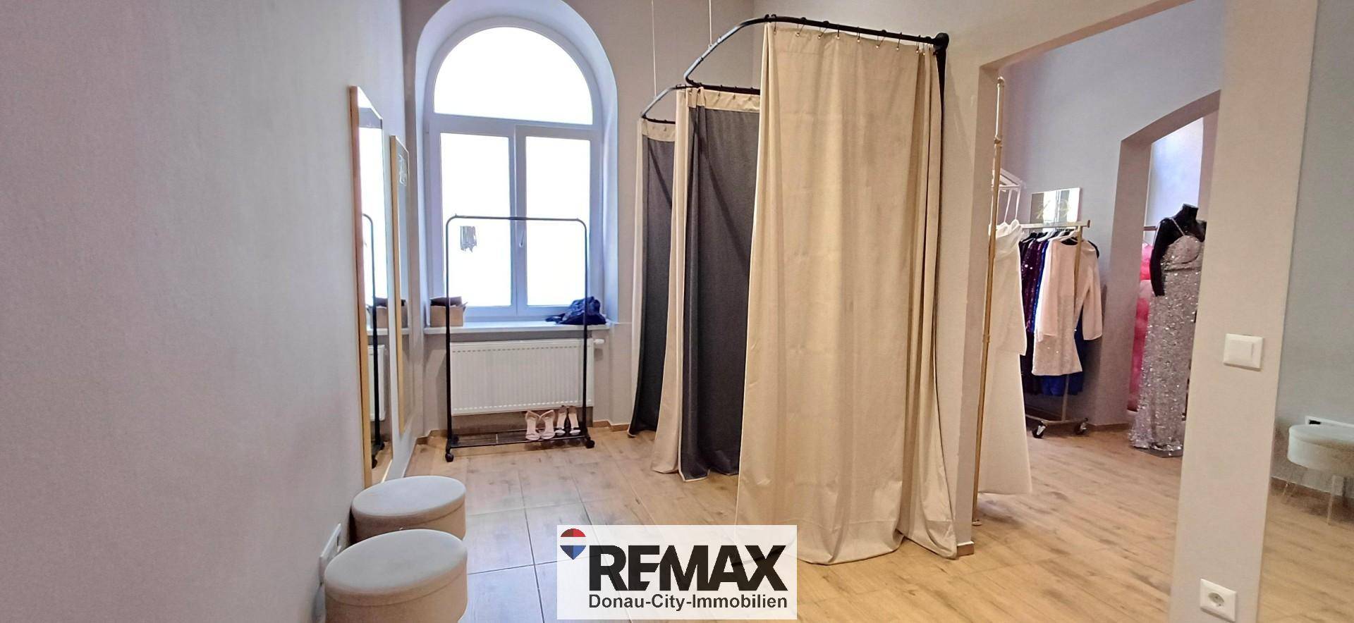 Umkleidebereich mit Vorhängen, Spiegel und Sitzgelegenheiten, ideal für Kunden.