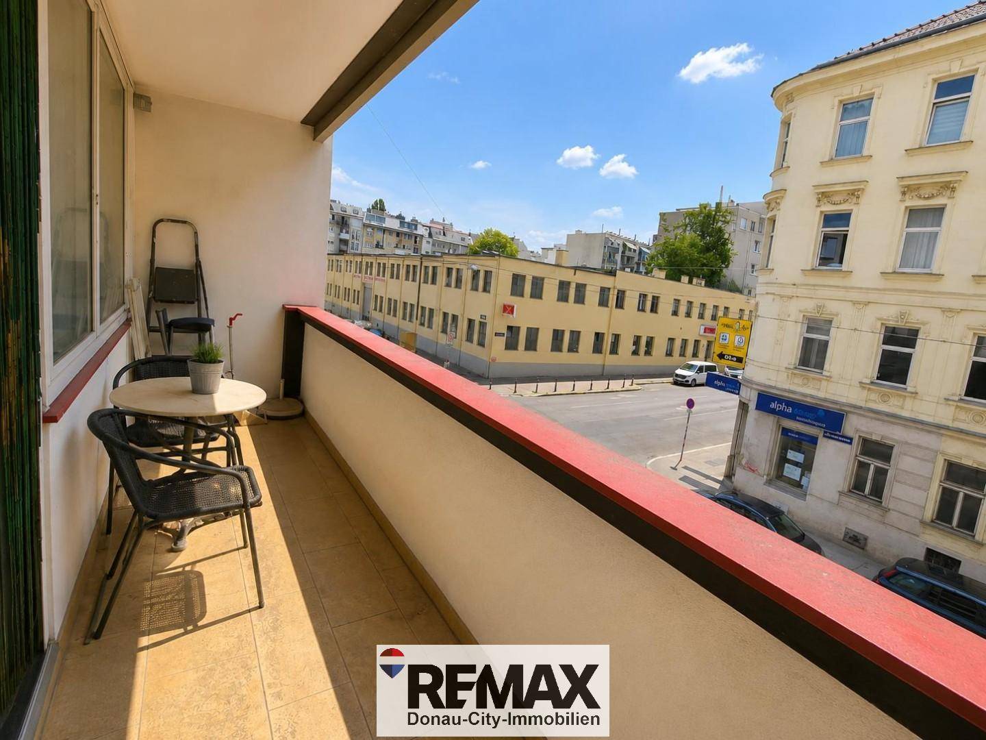 Balkon mit kleinem Tisch und Stühlen, bietet einen Blick auf die Stadt.