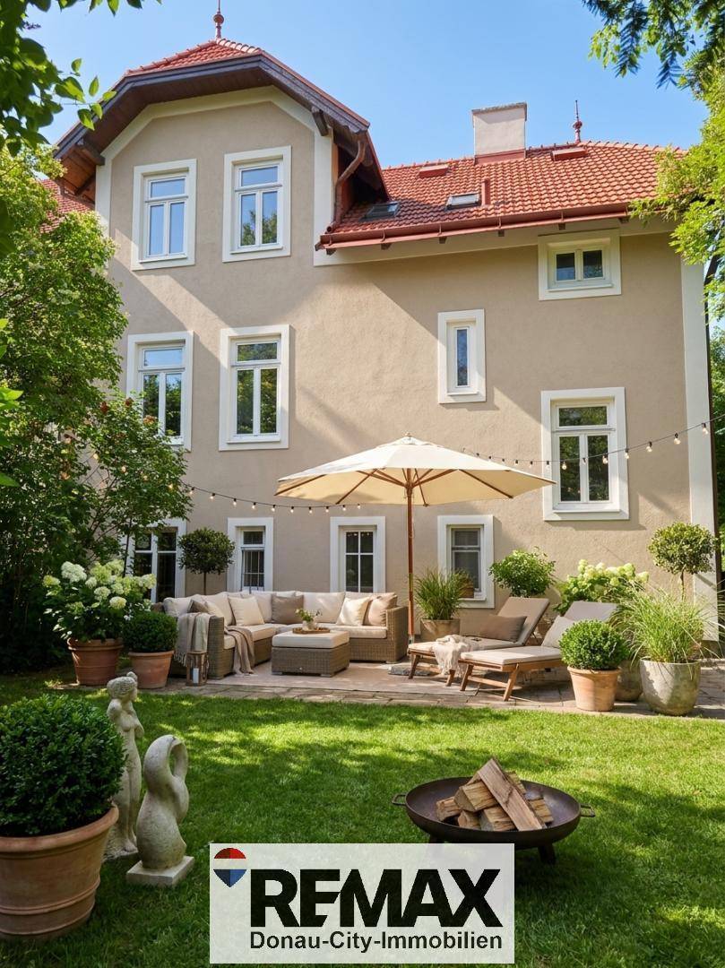 Idyllischer Gartenbereich mit möblierter Terrasse, Sonnenschirm und Feuerstelle hinter dem Haus.