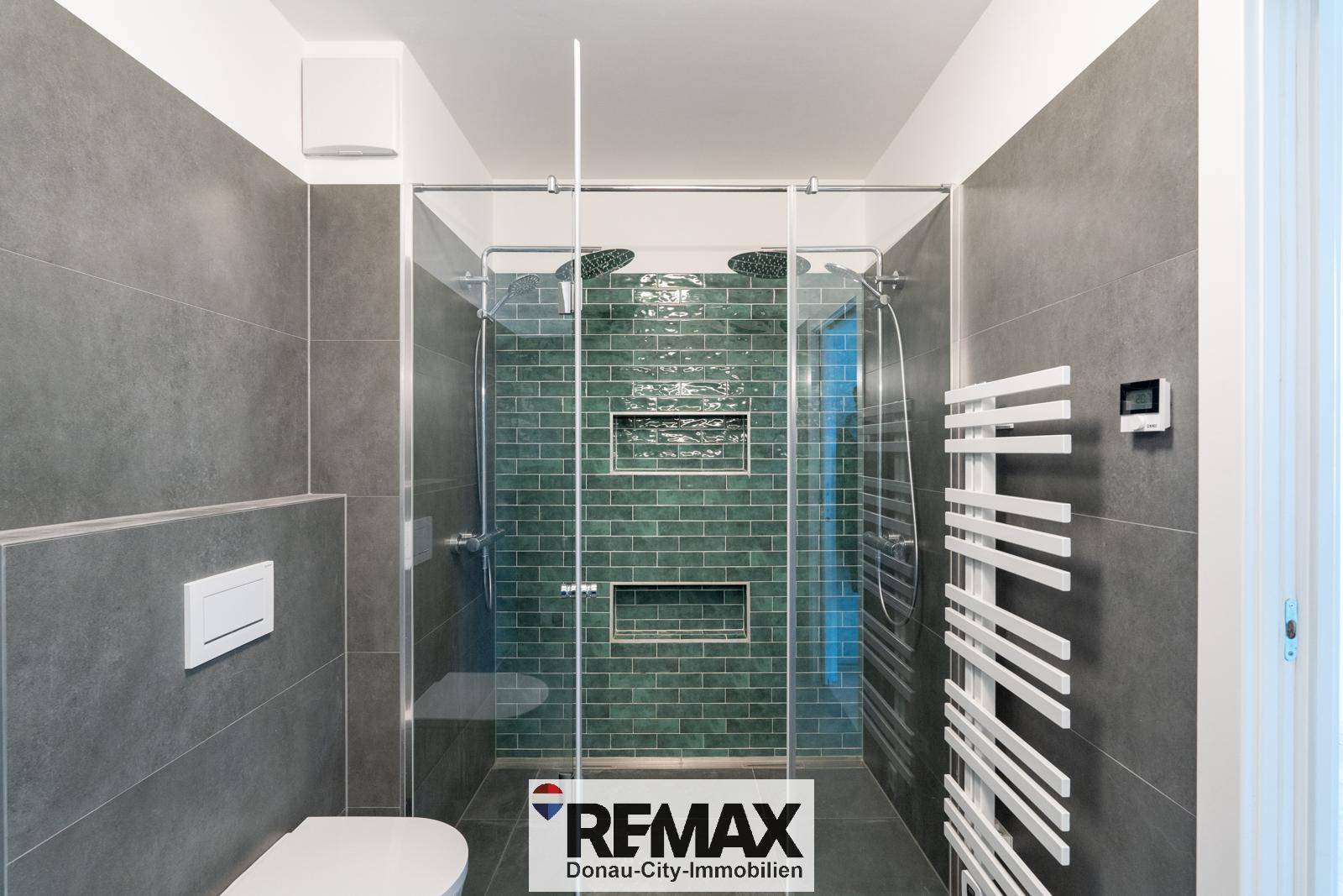 Modernes Badezimmer mit großer begehbarer Dusche, Regendusche und grauen Fliesen.