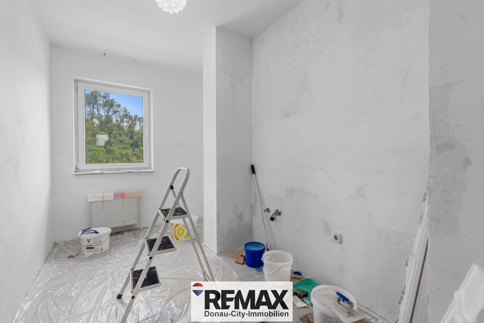 Badezimmer im Rohbauzustand mit Fenster und Heizkörper, bereit für den Ausbau.