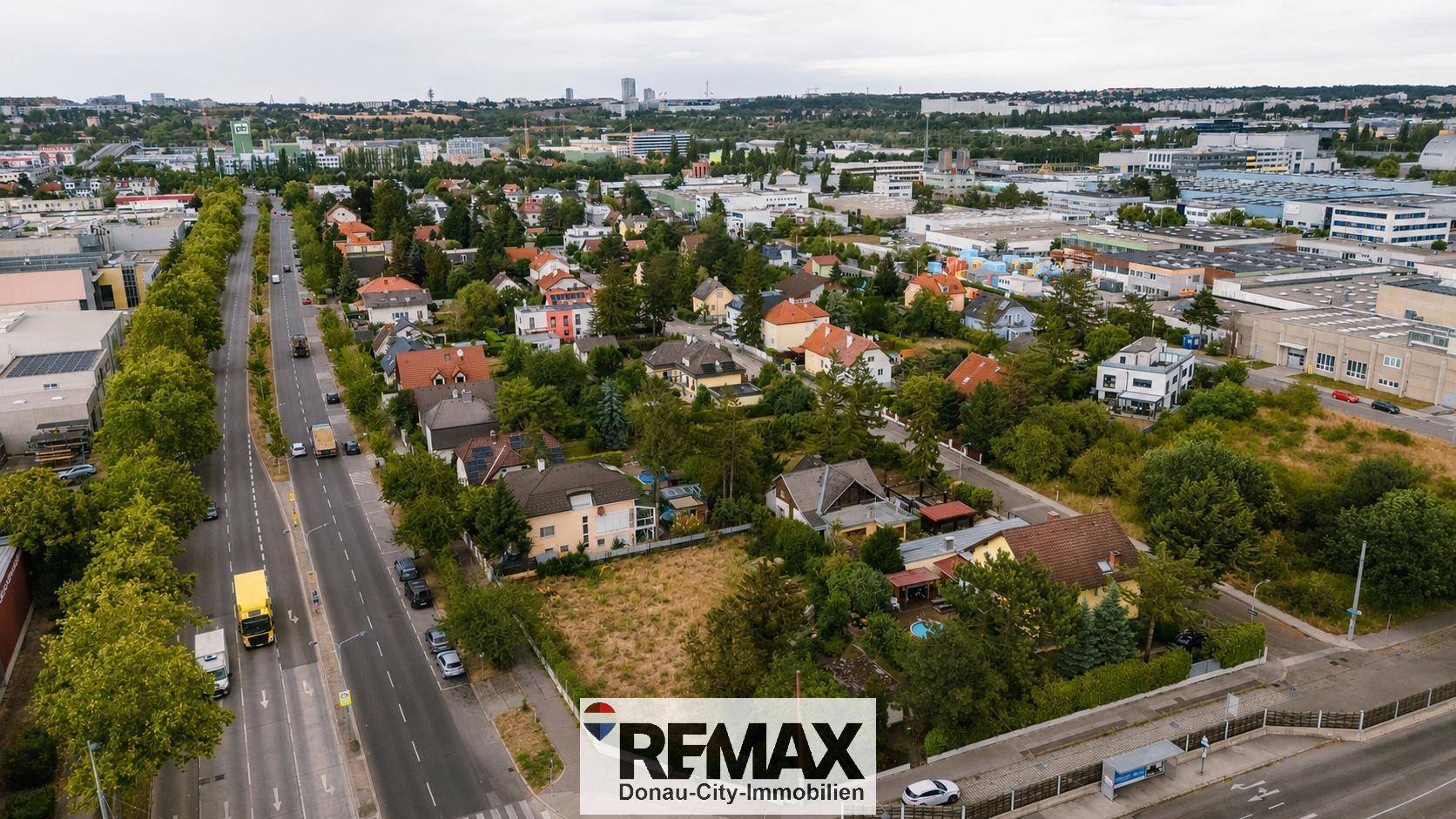 Luftaufnahme einer städtischen Umgebung mit Wohngebäuden, Straßen und viel Grün.