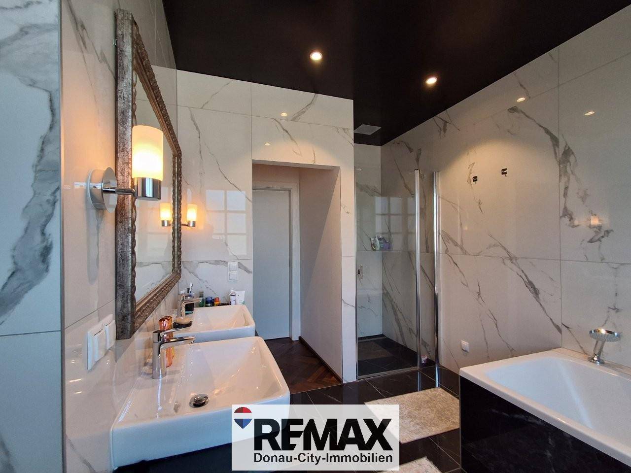 Modernes Badezimmer mit Marmorfliesen, Doppelwaschbecken und begehbarer Dusche.