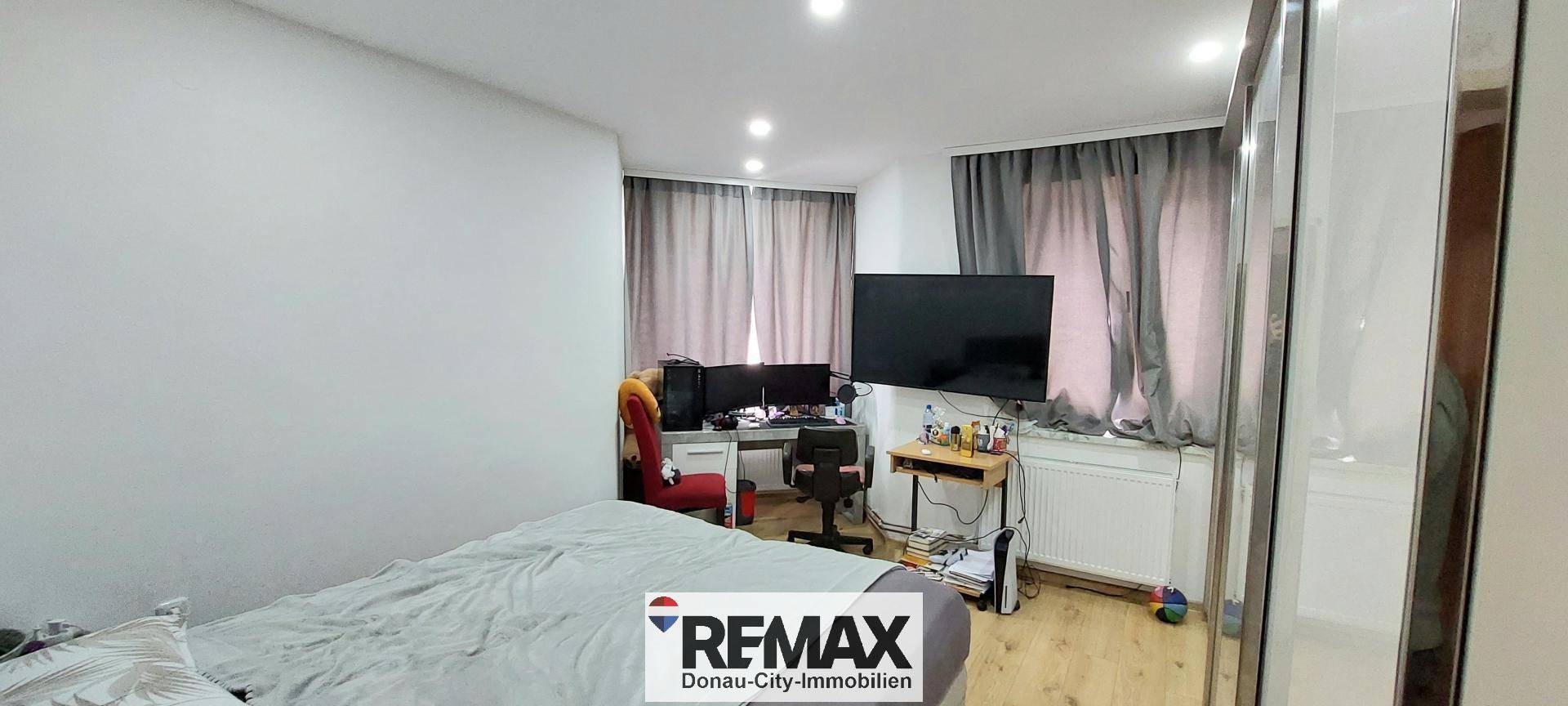 Schlafzimmer mit Bett und Arbeitsbereich, ideal für Home-Office oder Studium.