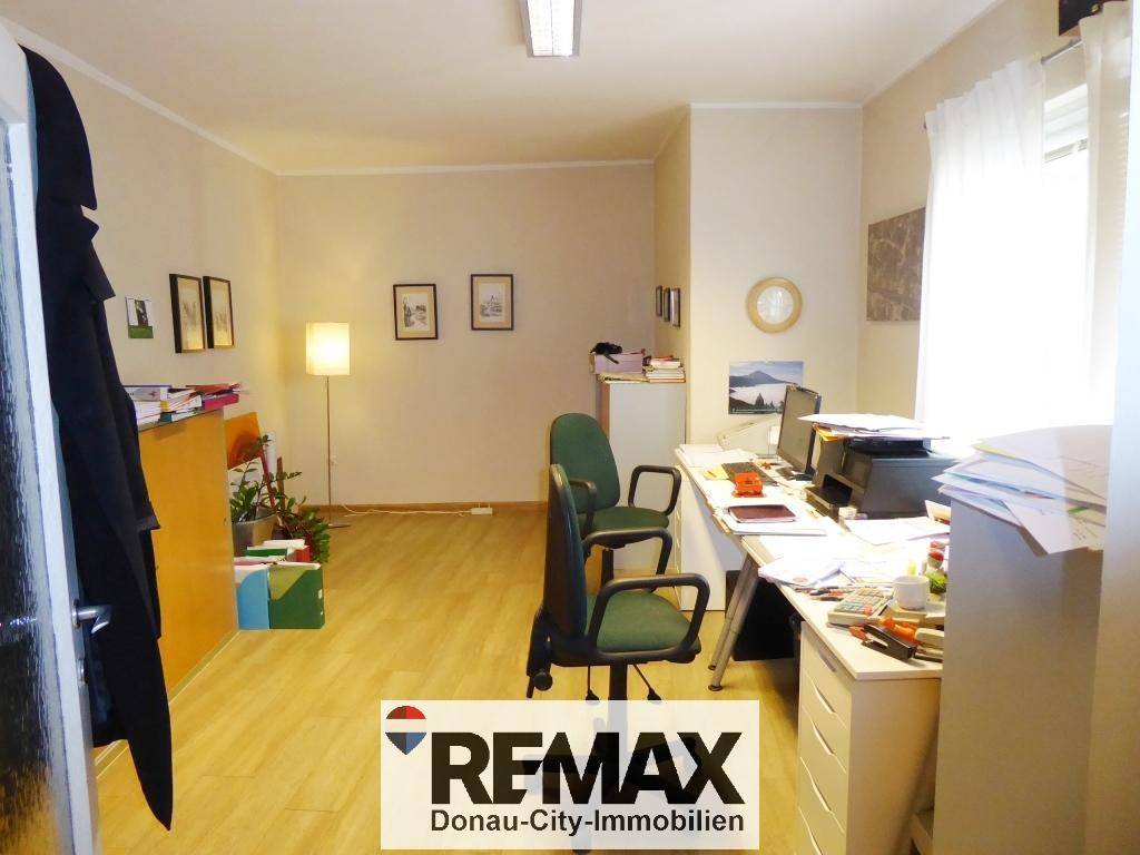 Funktionales Büro mit Schreibtisch, Bürostühlen und Fenster, ausgestattet für den täglichen Arbeitsablauf.