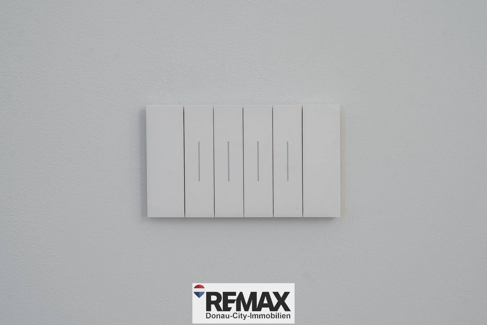 Modernes Lichtschalterpanel an einer weißen Wand, das die Beleuchtung steuert.