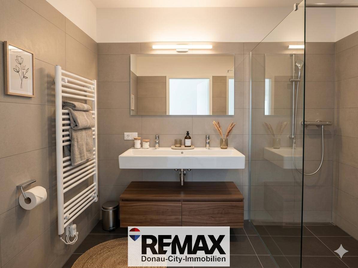 Modernes Badezimmer mit Doppelwaschbecken, großer Dusche und beheiztem Handtuchhalter.