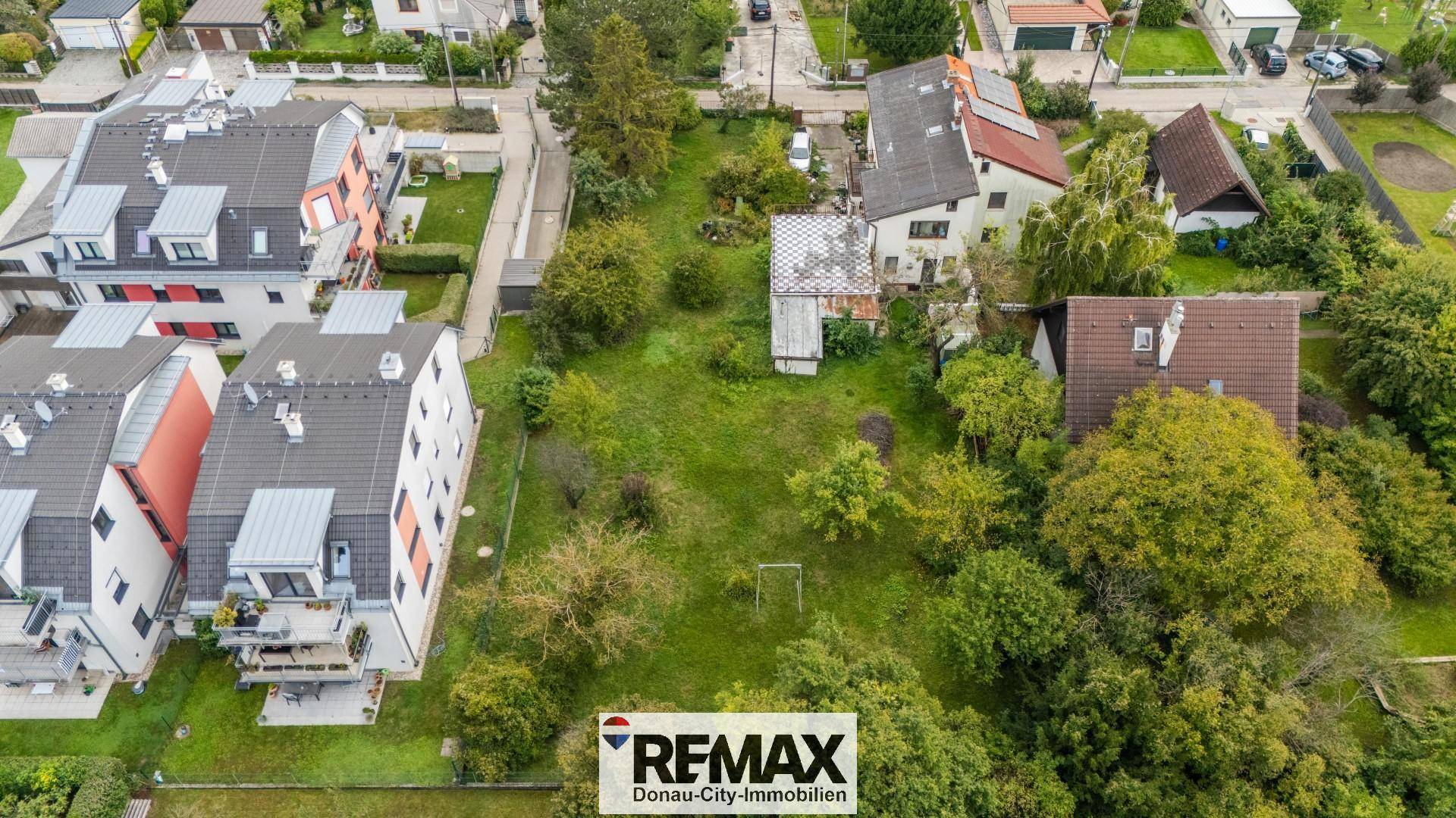 Luftaufnahme eines Grundstücks mit Bestandsgebäude und großem Garten, umgeben von Wohnbebauung.