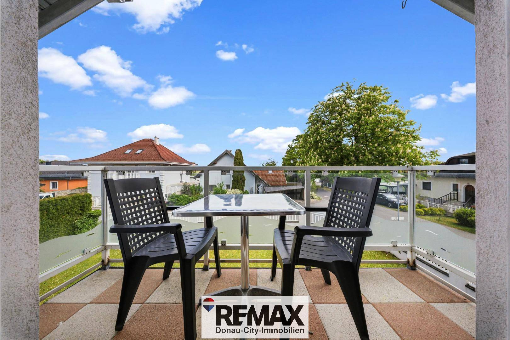 Kleiner Balkon mit Sitzgelegenheiten und Blick auf die Umgebung, ideal für entspannte Momente.