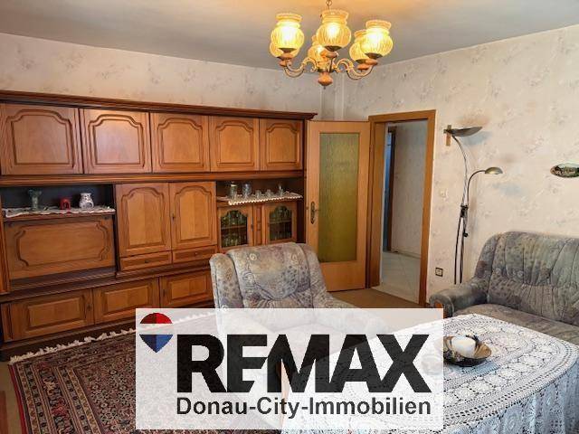 Gemütliches Wohnzimmer mit traditionellen Holzmöbeln und einem Kronleuchter.