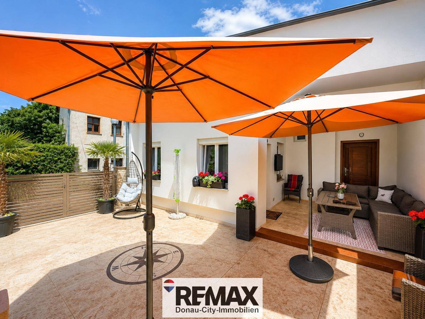 Großzügige Terrasse mit zwei Sonnenschirmen und bequemen Sitzgelegenheiten im Freien.
