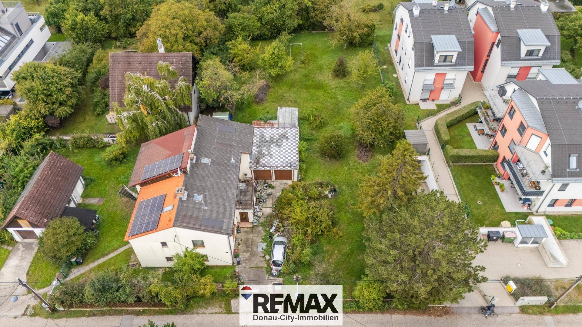Luftbild des Wohnhauses mit Solaranlagen auf dem Dach und weitläufigem, grünem Grundstück.