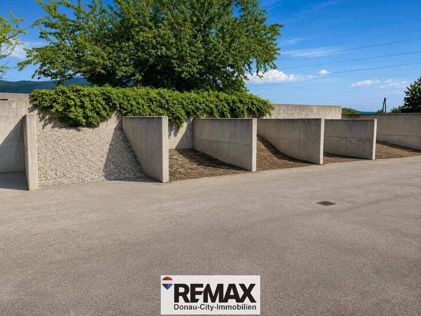 Betonmauern als Abgrenzung oder Stützelement im Außenbereich mit begrüntem oberen Rand.