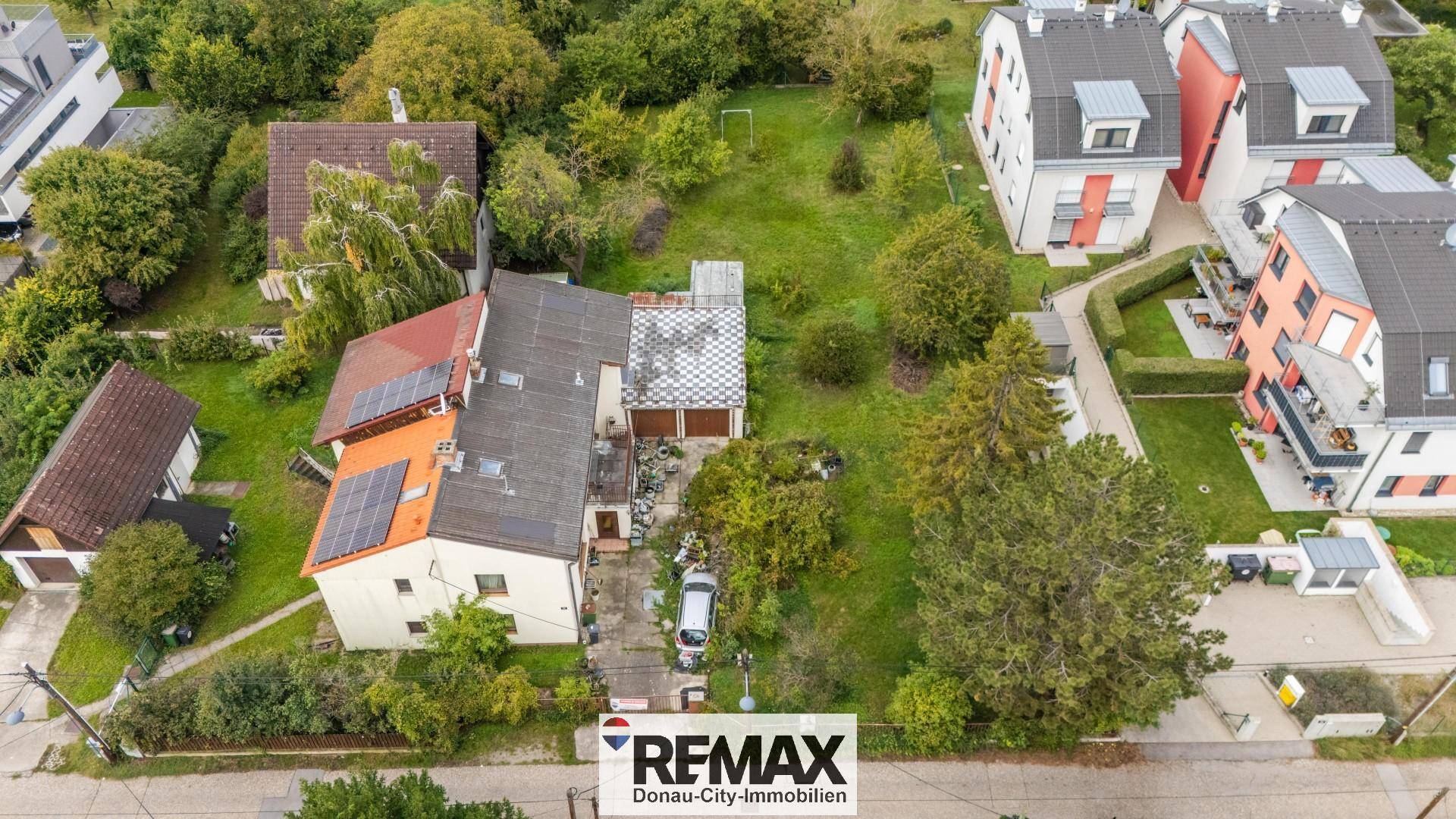 Luftbild des Wohnhauses mit Solaranlagen auf dem Dach und weitläufigem, grünem Grundstück.