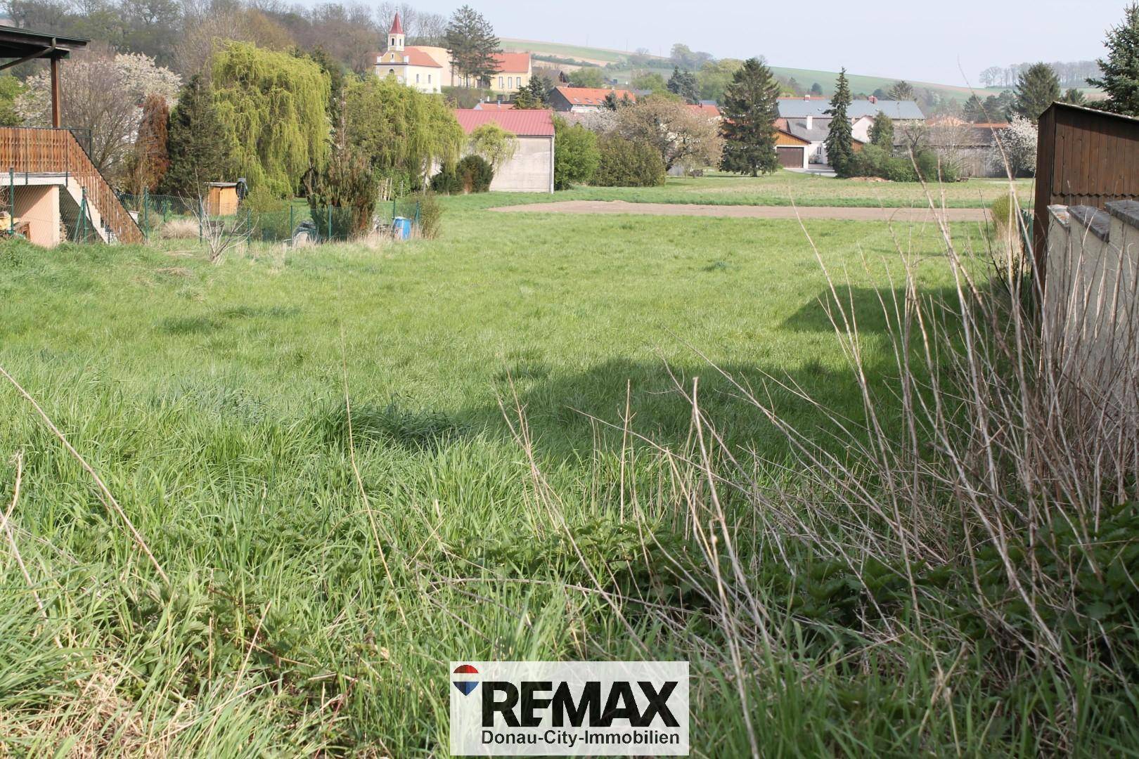 Weitläufiges grünes Grundstück mit Blick auf die umliegende ländliche Bebauung und Natur.