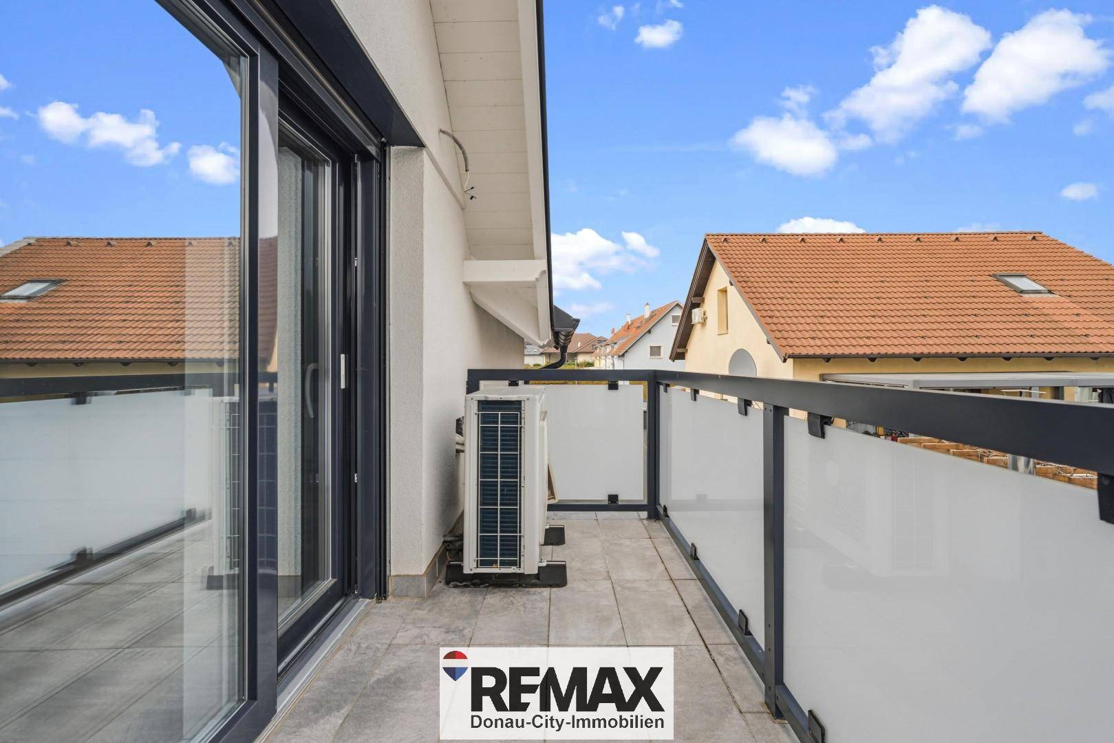 Kleiner Balkon mit Fliesenboden und Glasgeländer, ideal für frische Luft und Ausblick.