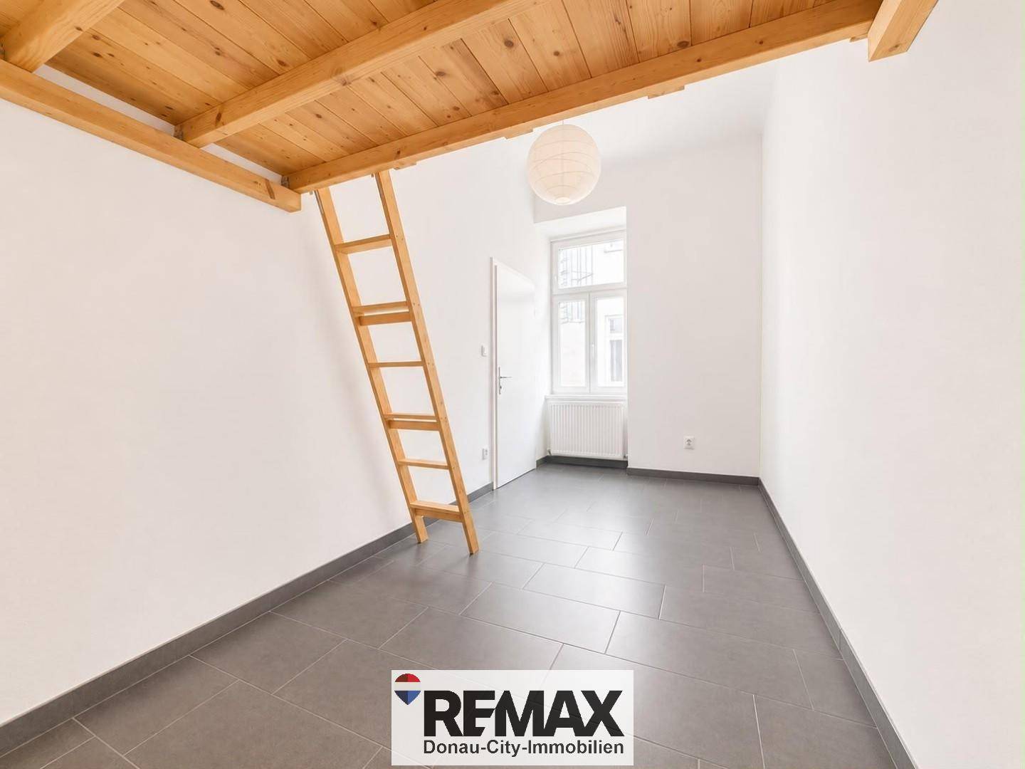 Helles Zimmer mit Hochbettkonstruktion aus Holz und grauen Fliesen, ideal für Kinder oder Gäste.